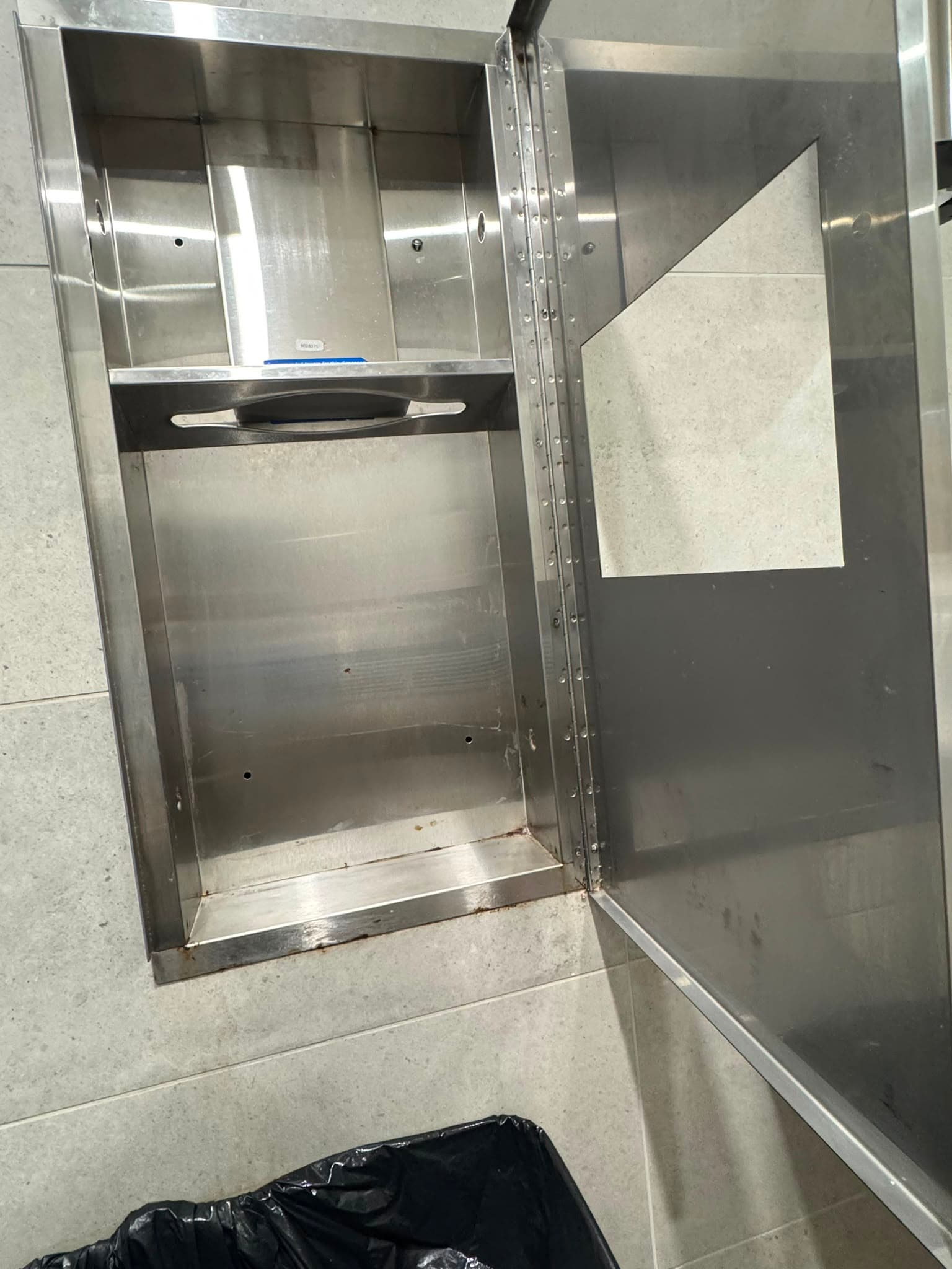 The same stainless dispenser recess scrubbed clean after cleaning