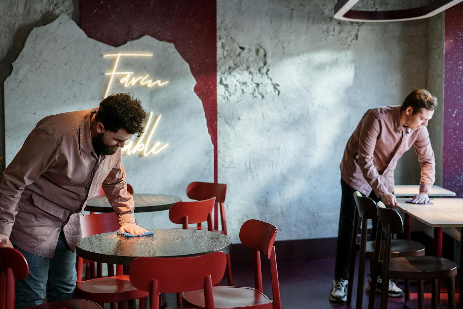 Staff cleaning tables in a modern restaurant interior